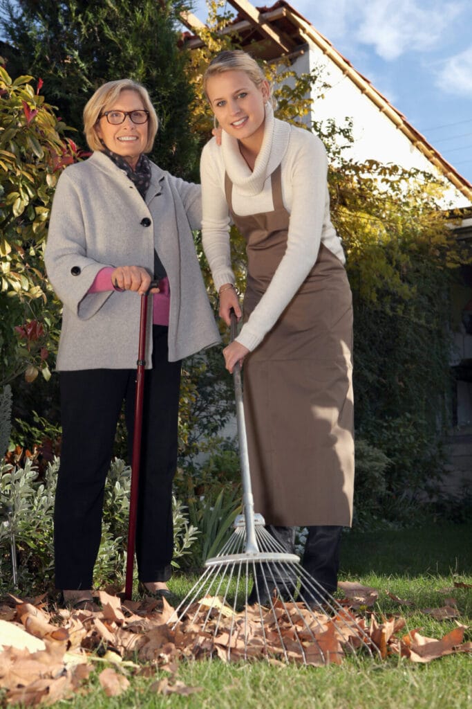 Two women raking leaves