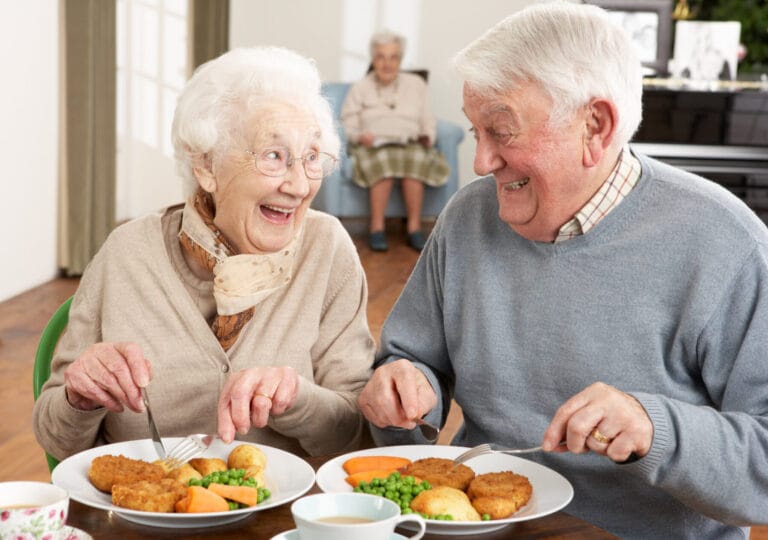 Senior Couple Enjoying Meal Together In Retirement Home